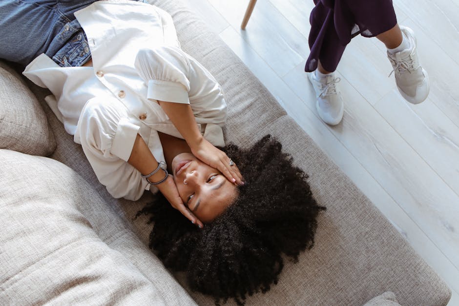 A woman lying on a couch during a therapy session, expressing emotions.